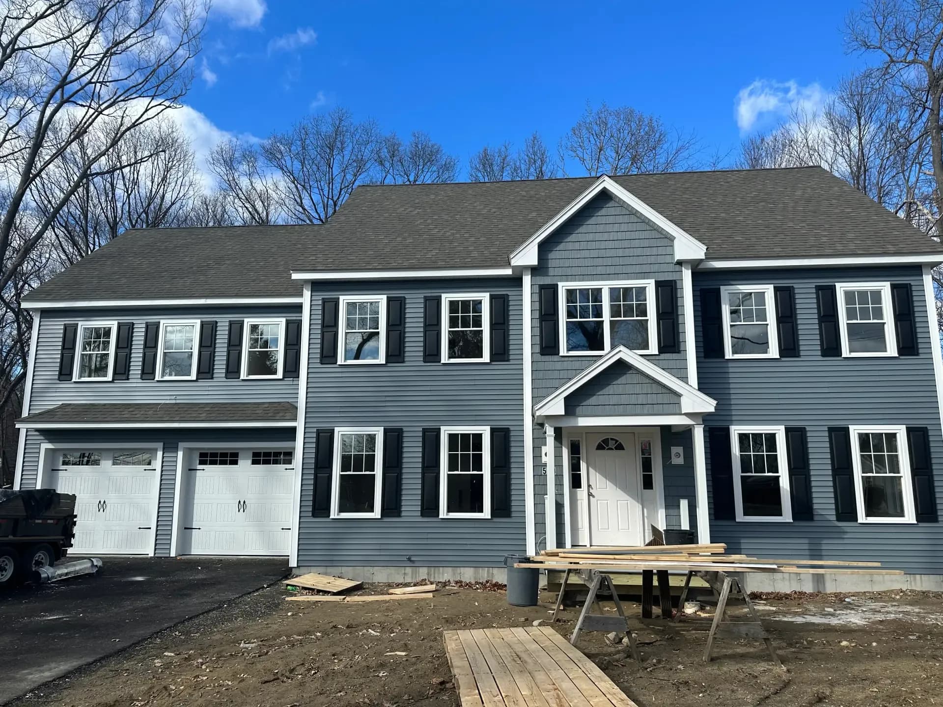 Full exterior renovation with gray siding and black shutters