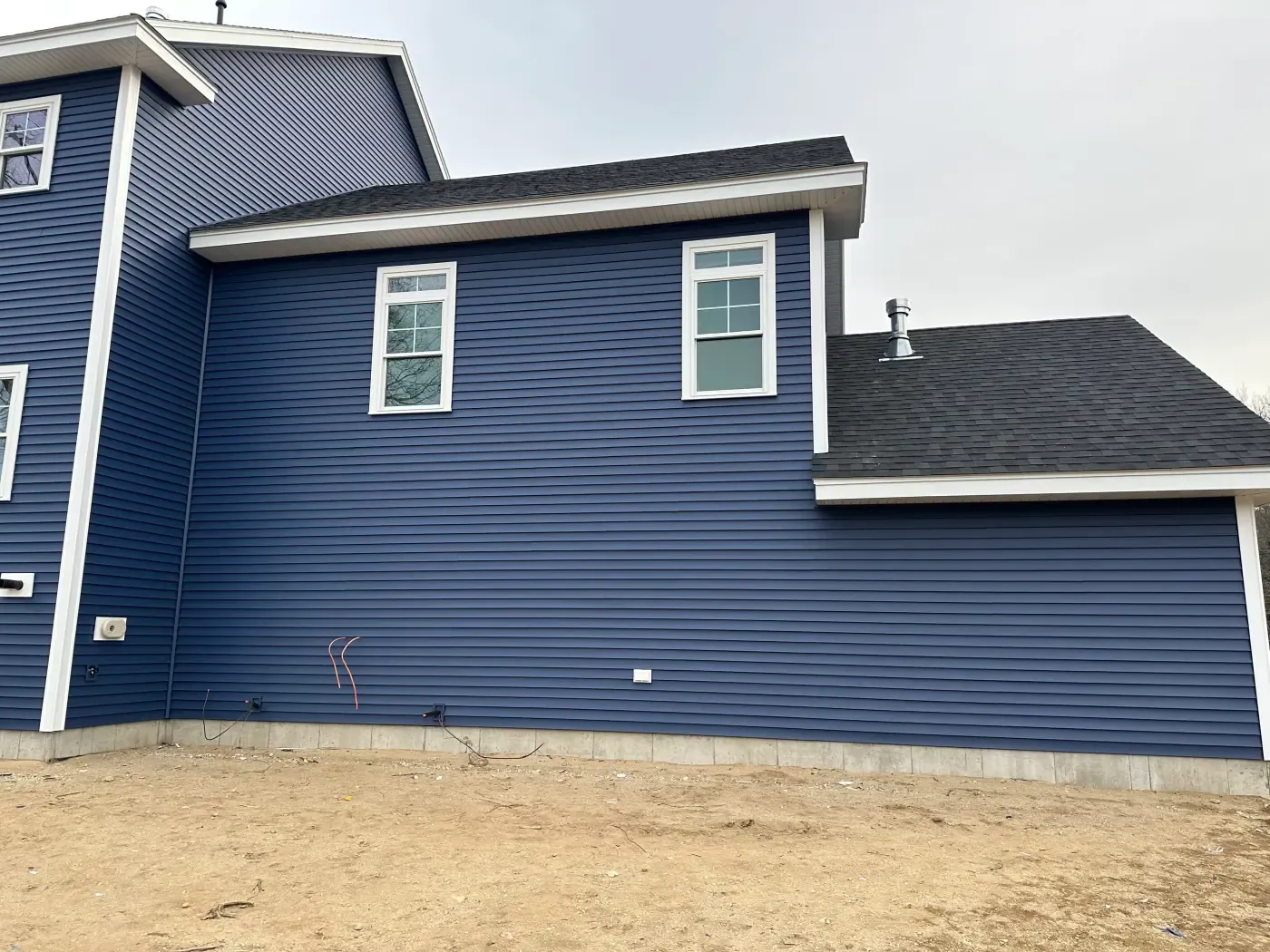 New windows set into navy blue lap siding